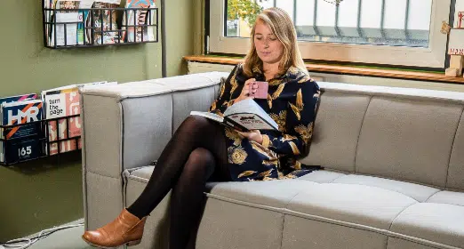 Vrouw die een boek leest op een bank